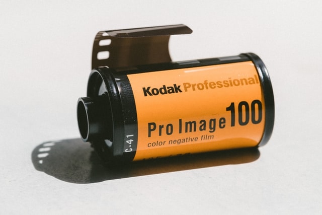 35mm color film canister of Kodak Pro Image ISO 100 film with the film leader sticking out. 