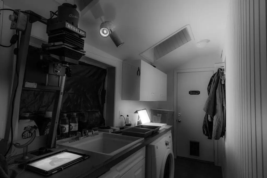 A DIY darkroom in a laundry room with running water and made complete dark by blocking out light coming into the window