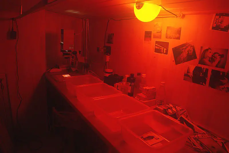 A photographic darkroom with a red safelight. 