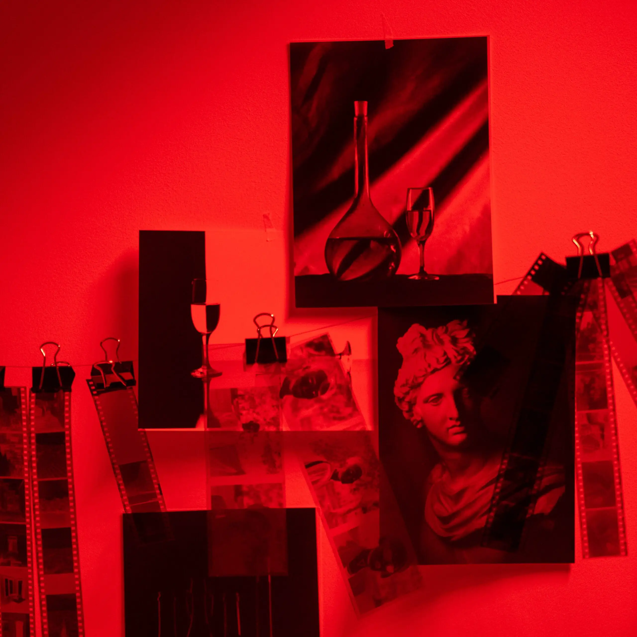 Photographic Darkroom in Red with different prints and negatives on the wall