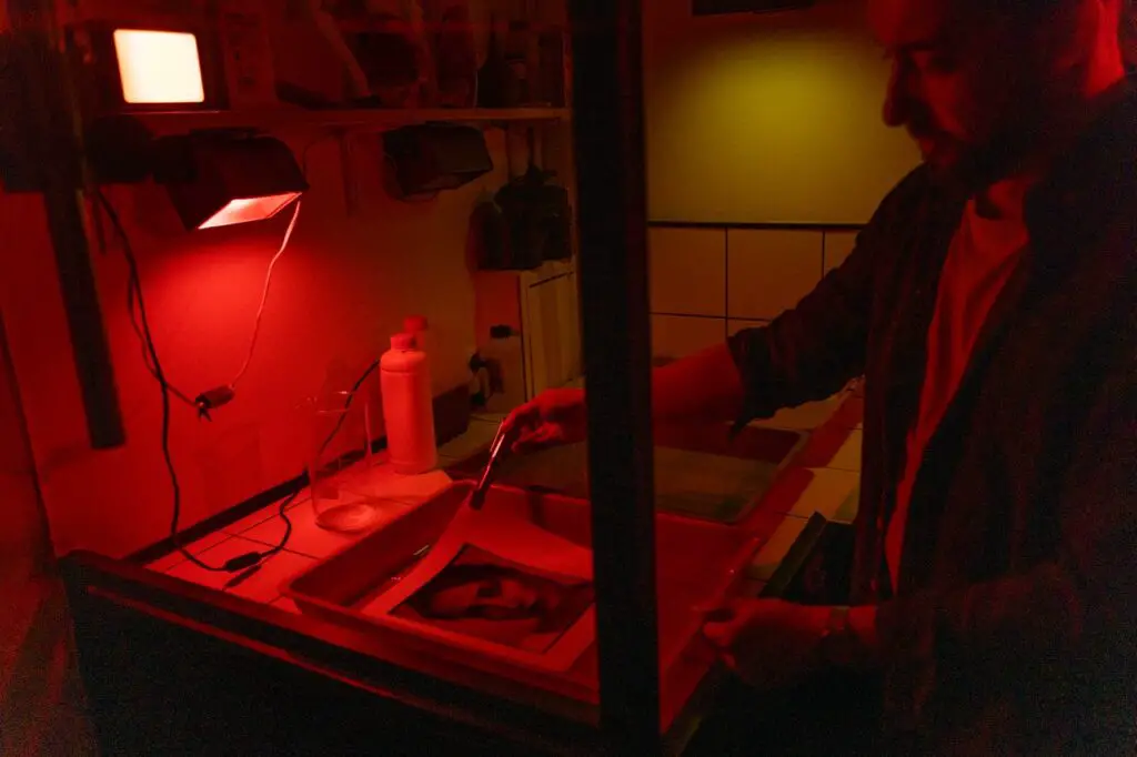 Developing a print in the darkroom with a red safelight